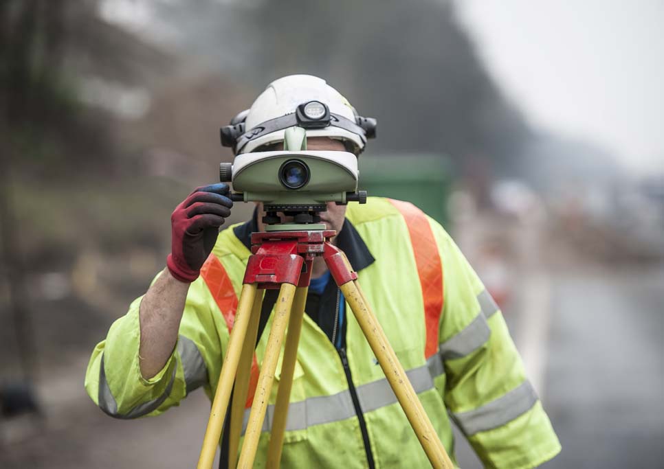 Worker using EDM Electronic distance measuring tool