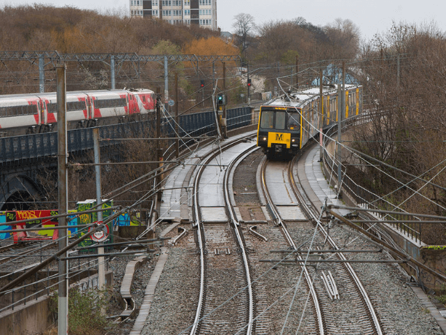 Newcastle Metro tram with passing train on parallel tracks