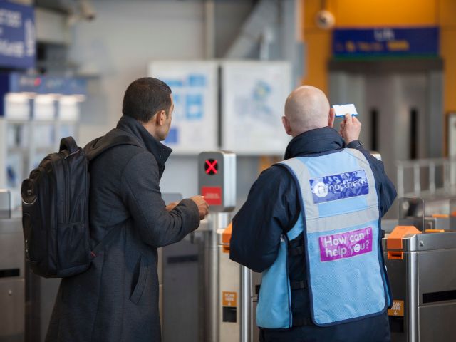 Northern Trains staff with passenger at barriers